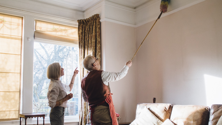 man dusting a ceiling