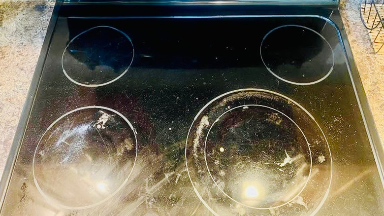 A glass stovetop with white film and other residue.