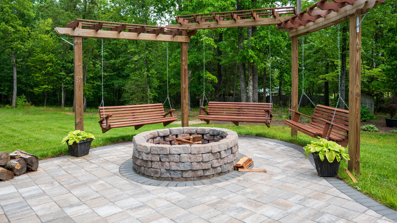 Stone fire pit surrounded by swings