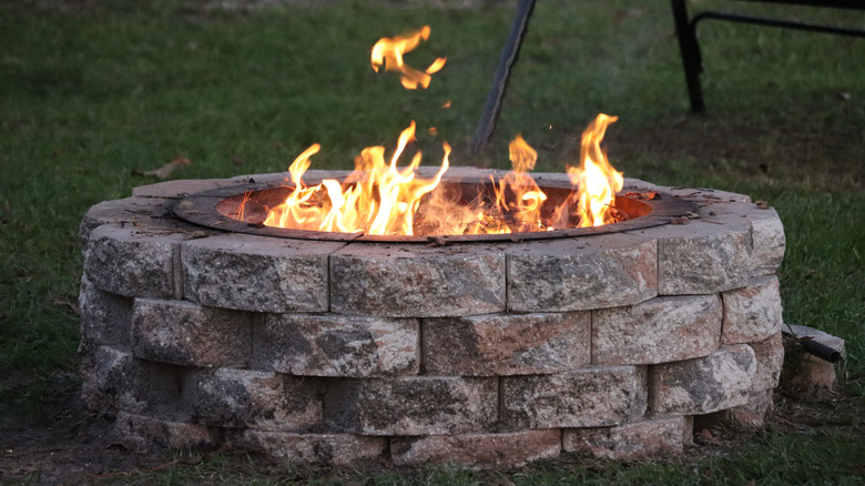 Brick fire pit with a fire burning it it