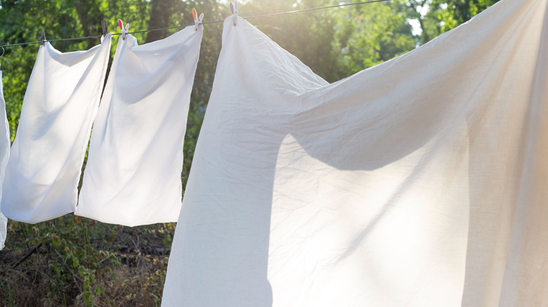 white bed linens on clothesline
