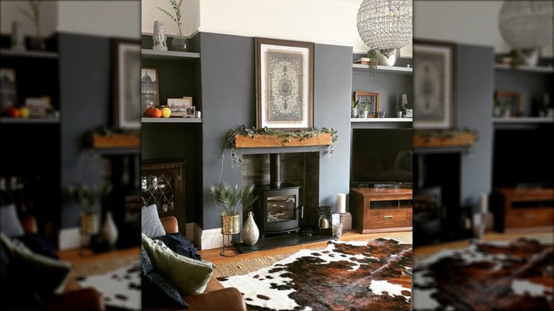 A cozy living room with a wood burning stove and layered jute and cow hide rugs.