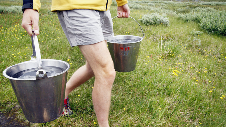a person carrying two buckets