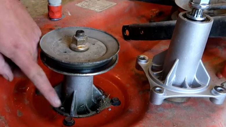 person replacing lawn mower spindle