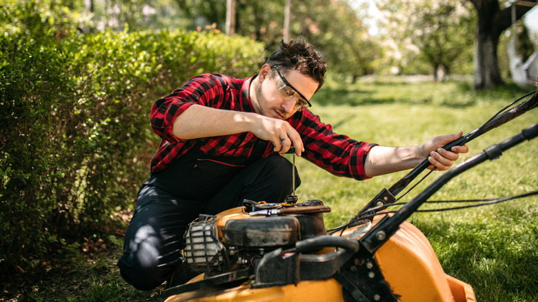 person maintenancing their lawn mower