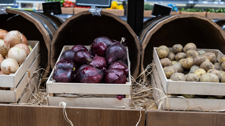 Red onions in a box in the produce section of a high-end grocery store.