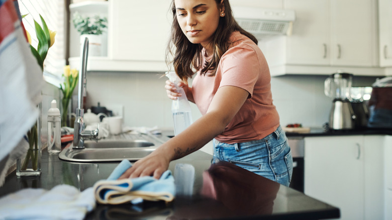 A woman giving her kitchen surfaces a clean
