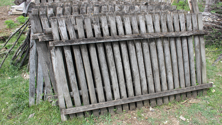 pieces of an old wood fence on a green lawn