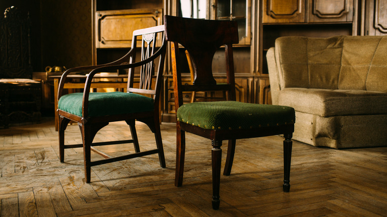 Two antique chairs set out on a wood floor