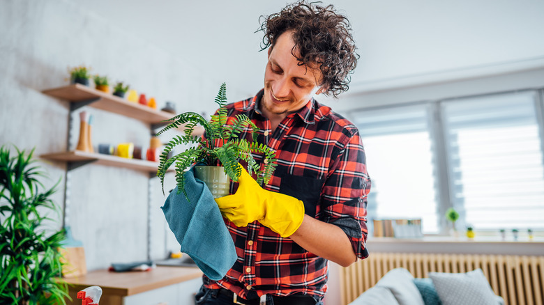man wiping flower pot