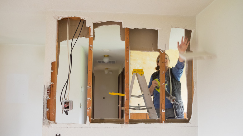 woman removing drywall