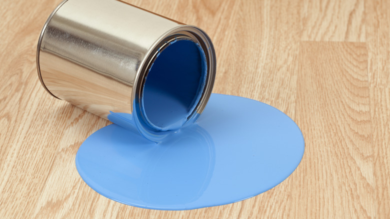 Blue paint spilt on hardwood floor