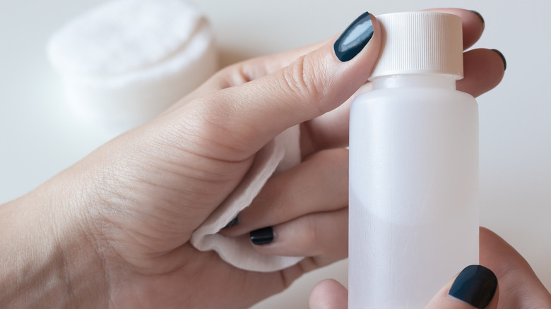 Hands holding nail polish remover
