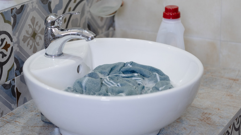 Applying commerical stain remover to an item of white clothing.