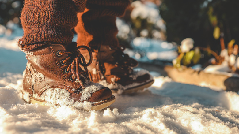 person wearing leather boots with snow on them