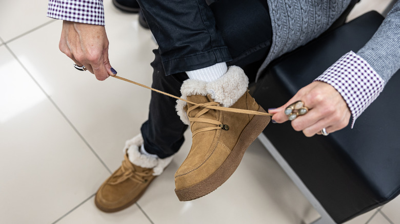 person tying up their suede winter boots