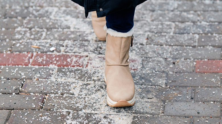 person wearing boots walking on rock salt