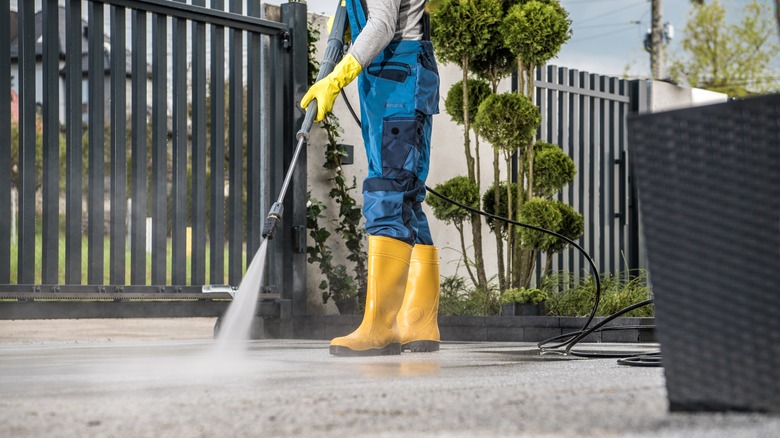 person pressure washing driveway