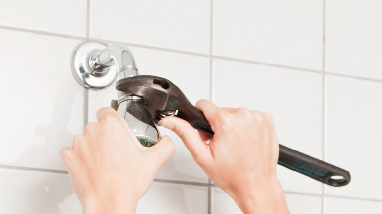 Unscrewing a showerhead with an adjustable wrench