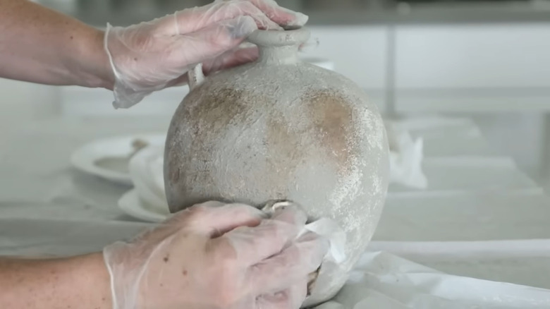 Hand applying texturing to a ceramic jar