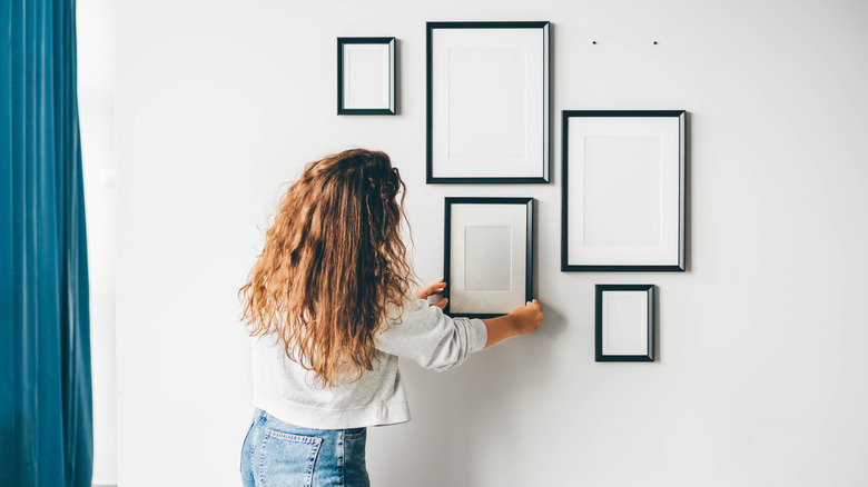 woman hanging frame