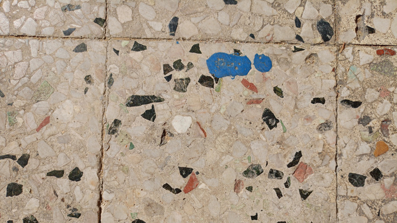 A closeup of an old and stained terrazzo tile floor.
