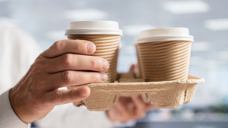 person carrying cardboard drink holder