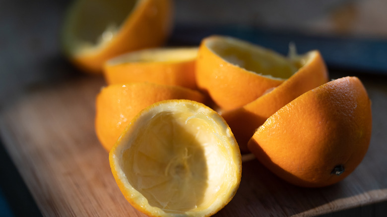 Orange peel halves on a wooden board