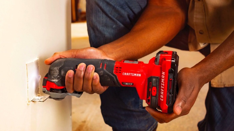 person cutting oscillating tool