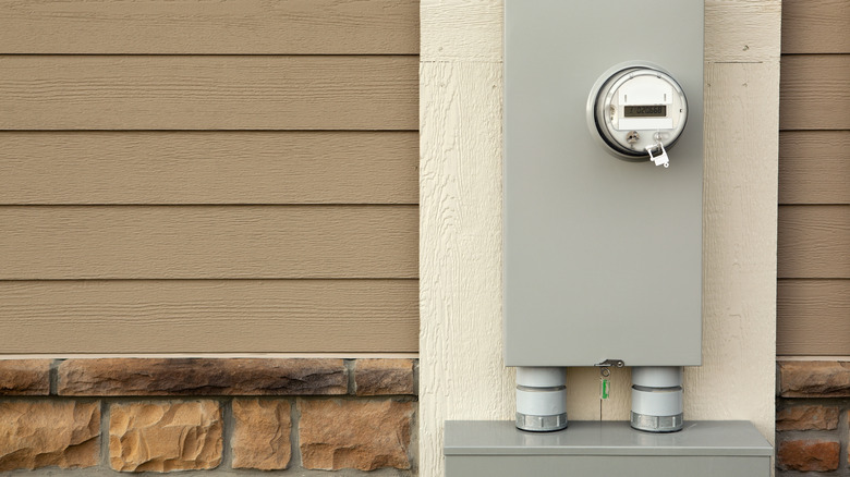 Electricity meter mounted on the outside of a house.
