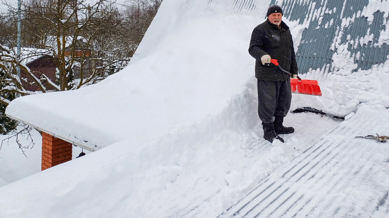 Man clearing snow from flat roof
