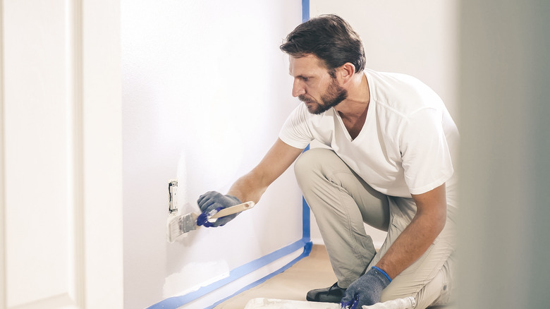 Man painting over outlet