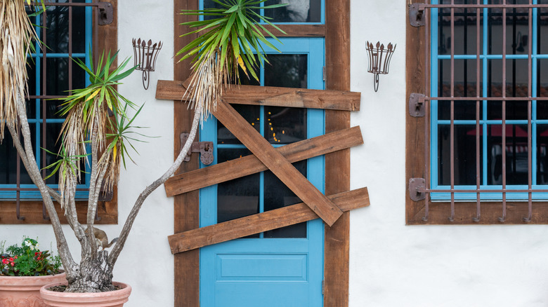 The exterior of a home with a boarded-up door