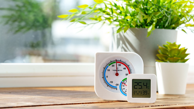 Digital Thermometer Displaying Temperature and Humidity Near Window