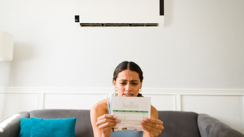 A worried woman looking at the electricity bill