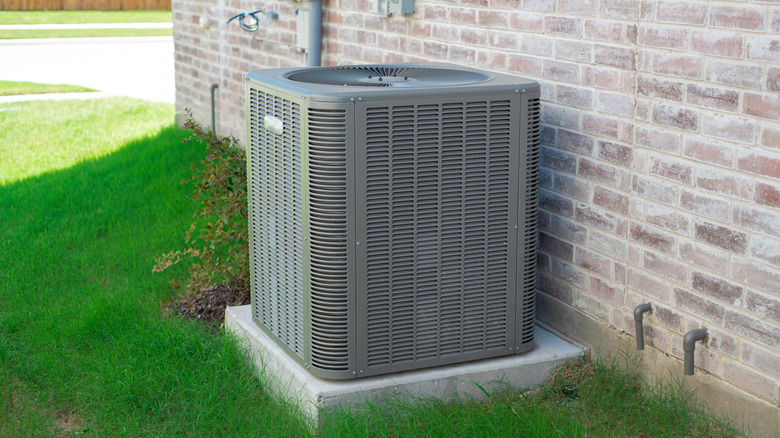 The outdoor unit of an AC next to a brick wall