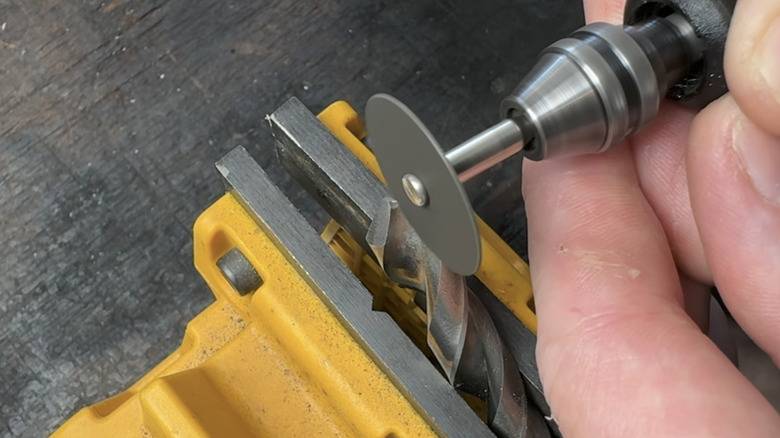 Person uses a Dremel rotary tool to sharpen a dull drill bit.