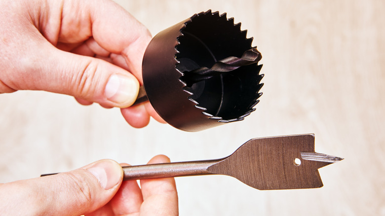 A hole saw and a spade bit showing the different cutting edges