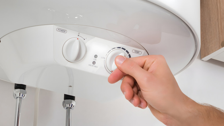 Someone adjusting the temperature of a water heater