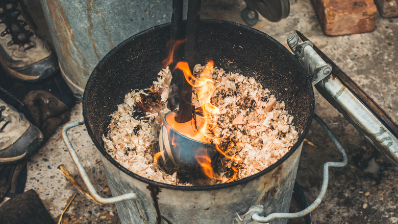 Raku pottery being submerged in sawdust