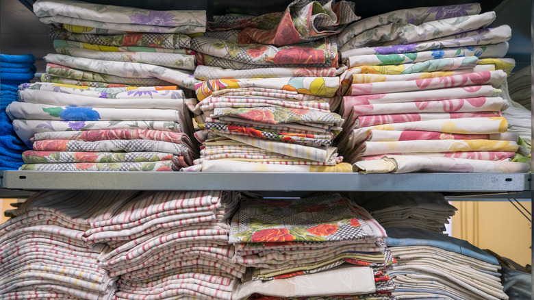 Shelves of neatly folded natural fabrics at the thrift store.