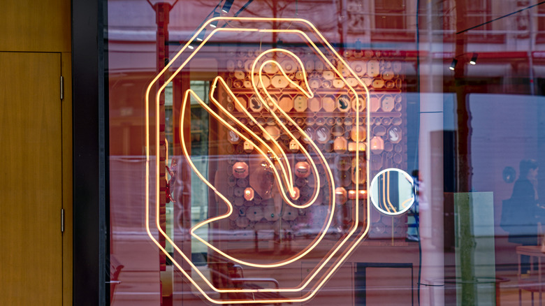 Lit up Swarovski swan logo in a window
