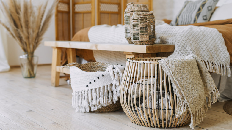 basket with blankets next to bed