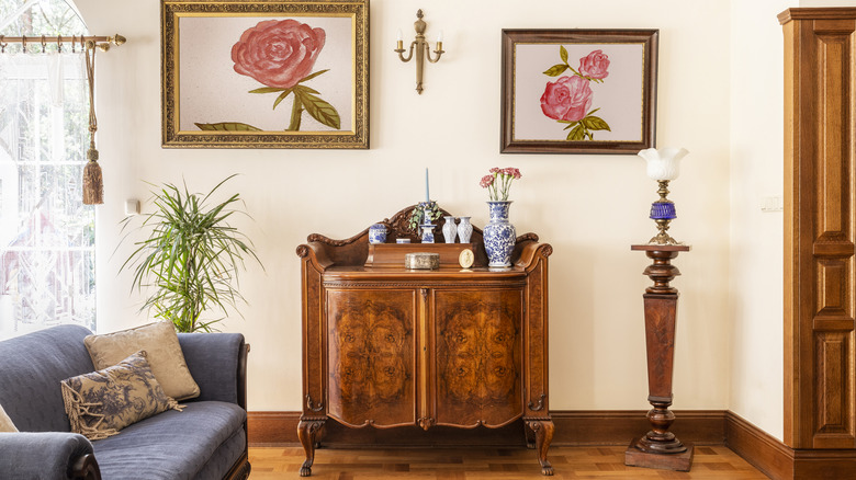 An antique cabinet with decorative vases on top in a room