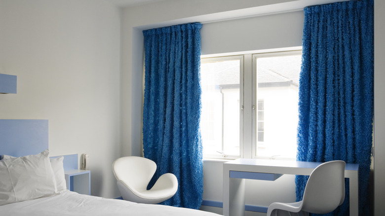 Textured blue drapes hanging in a bedroom