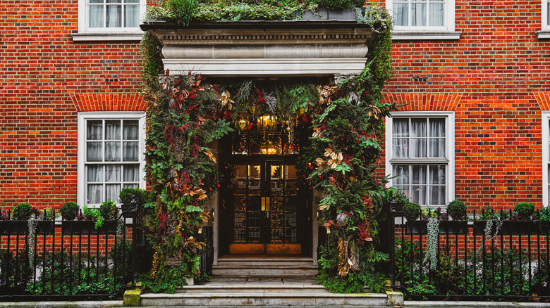 The front entrance to a brick apartment building with garland around the entranceway