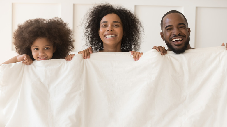 Family holding duvet