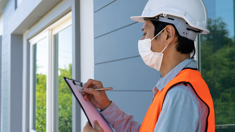 masked home inspector with clipboard