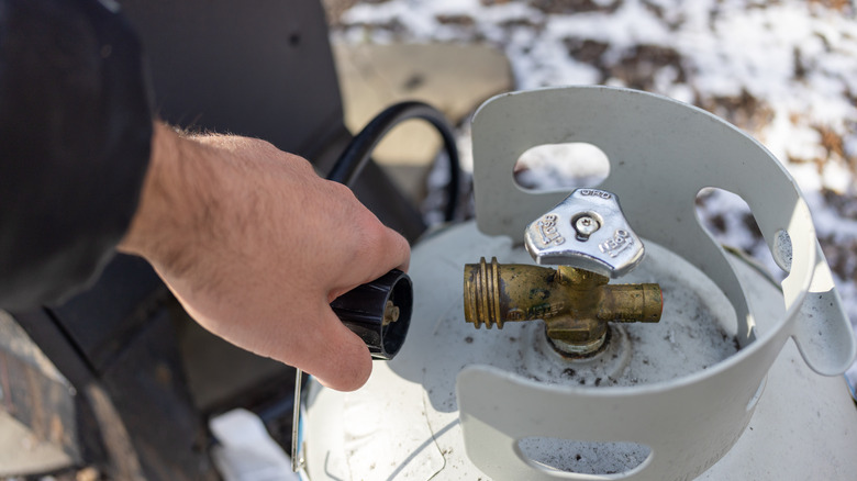 A homeowner attaches smoker to propane tank