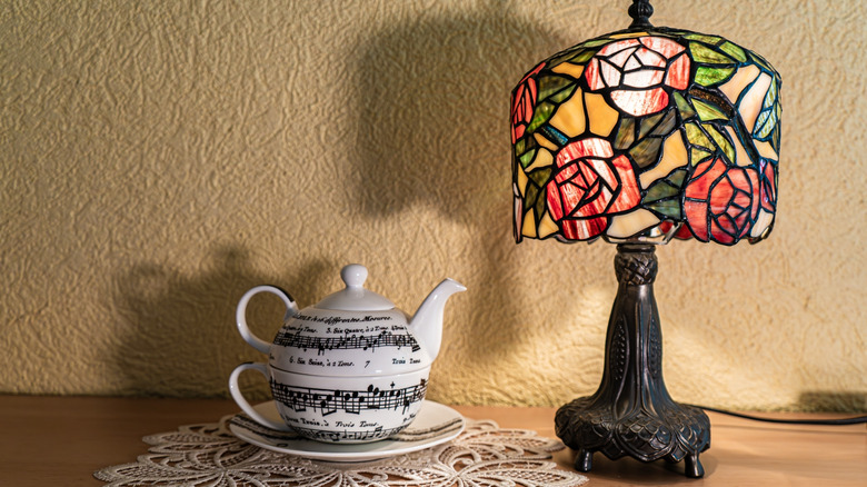Tiffany flower lamp on table by teapot